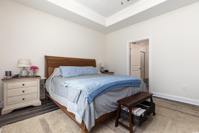 bedroom featuring crown molding, a tray ceiling, and dark hardwood / wood-style floors