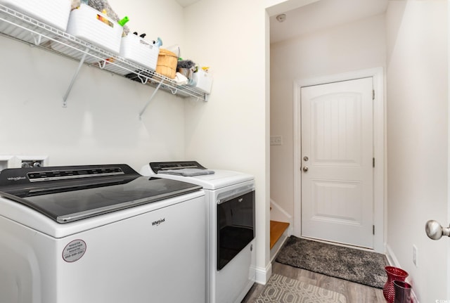 laundry room with washer and dryer and wood-type flooring