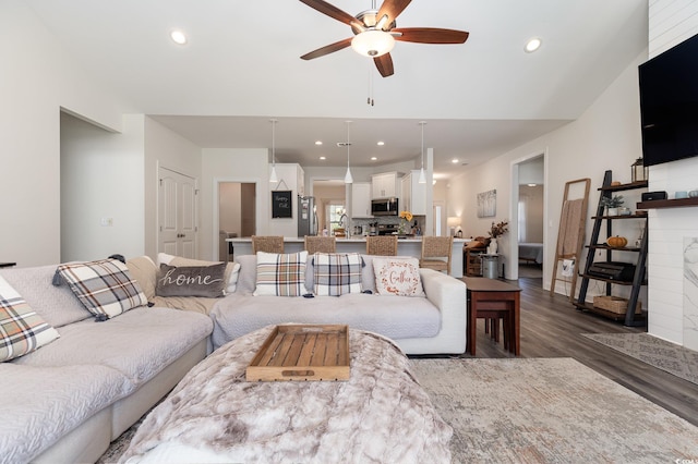 living room featuring dark wood-type flooring and ceiling fan