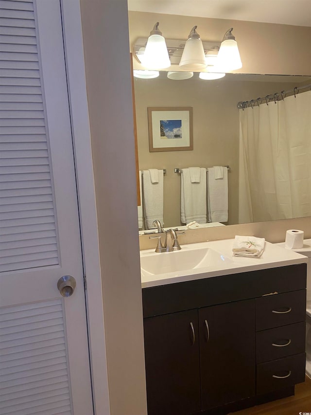 bathroom featuring vanity, toilet, and hardwood / wood-style flooring