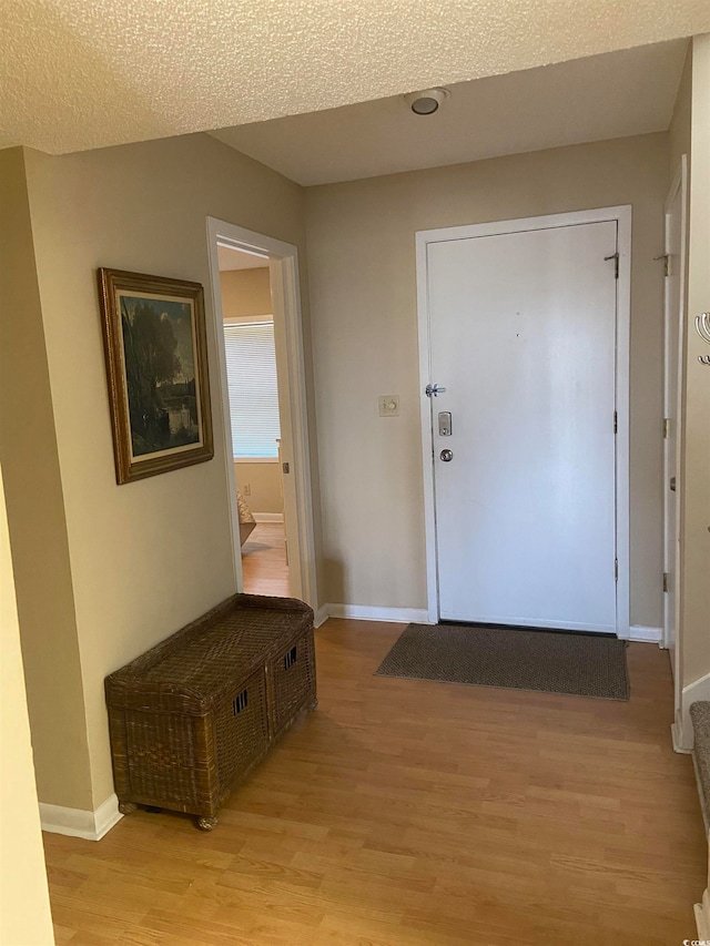 entrance foyer with light hardwood / wood-style flooring and a textured ceiling