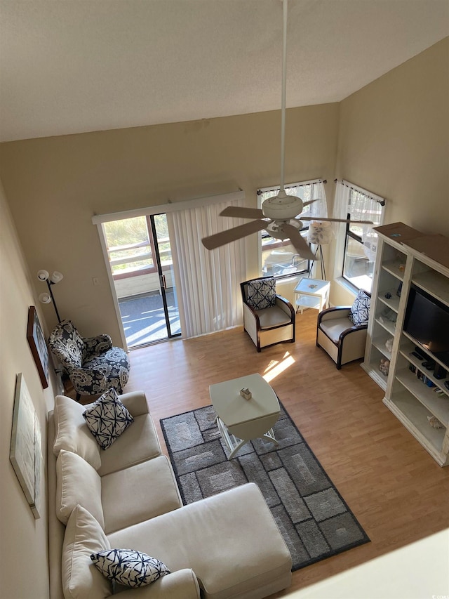 living room with vaulted ceiling, hardwood / wood-style flooring, and ceiling fan