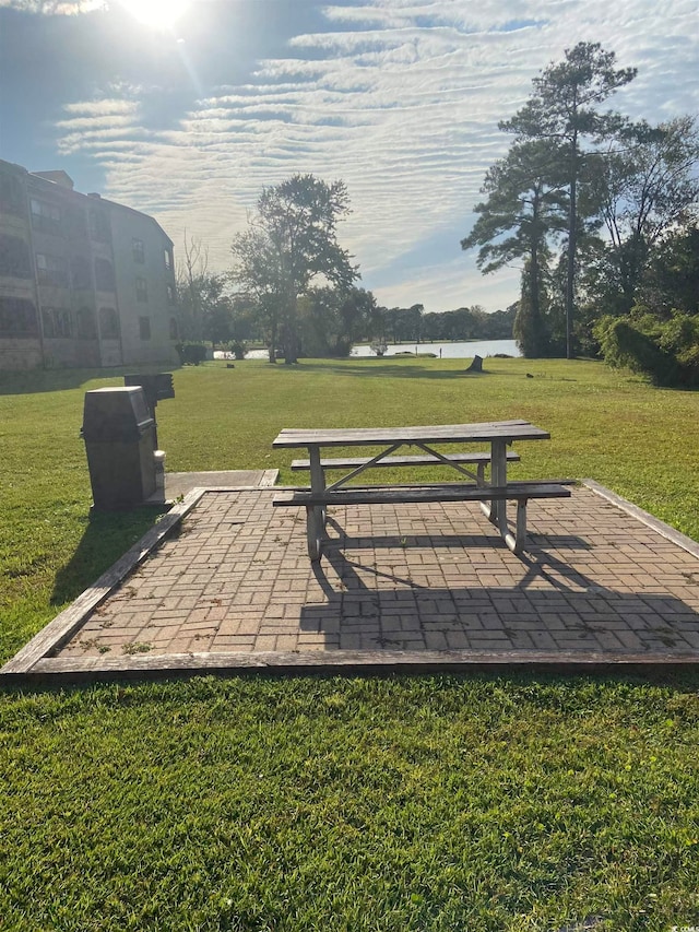 view of property's community with a patio area and a lawn