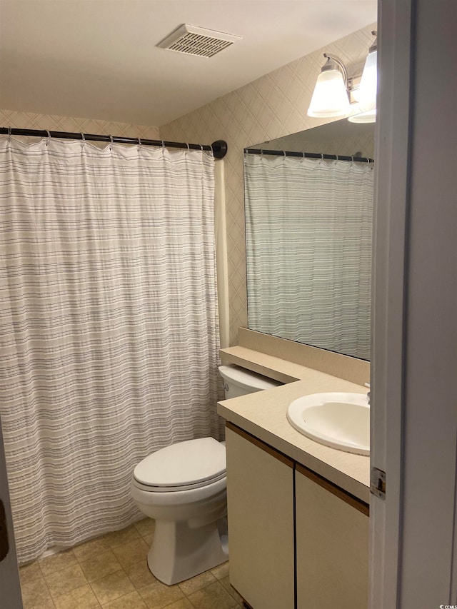 bathroom featuring vanity, toilet, and tile patterned flooring