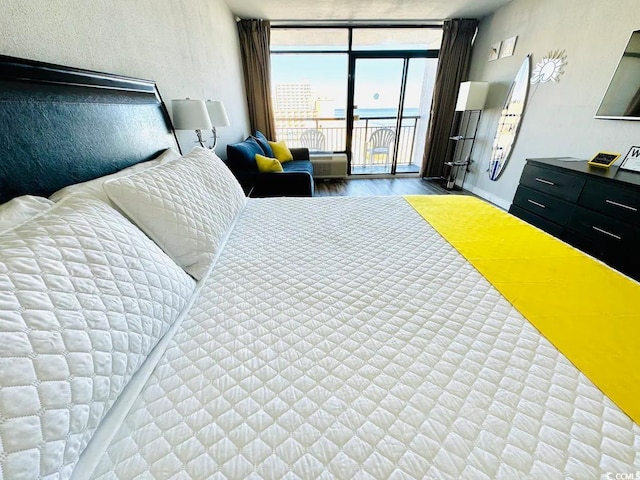 bedroom featuring access to outside, floor to ceiling windows, and hardwood / wood-style floors