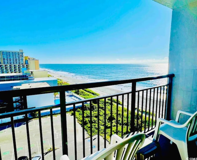 balcony with a water view and a view of the beach