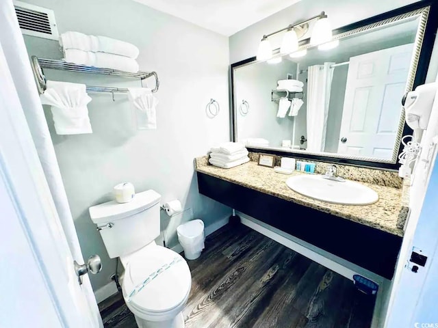 bathroom with vanity, hardwood / wood-style flooring, and toilet