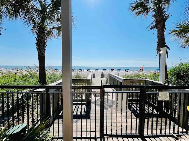 deck featuring a water view and a beach view