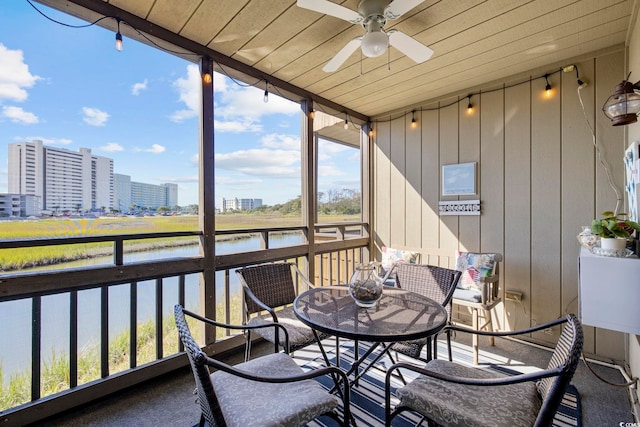 sunroom / solarium featuring a water view, wooden ceiling, and ceiling fan