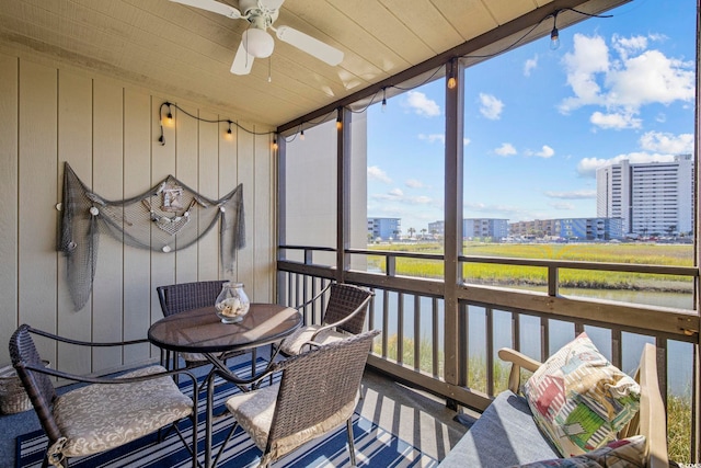 sunroom with ceiling fan, wood ceiling, and a water view