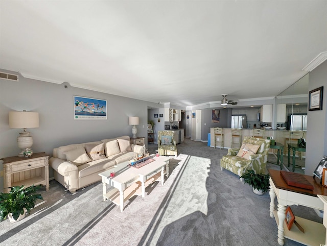 living room with dark colored carpet, crown molding, and ceiling fan