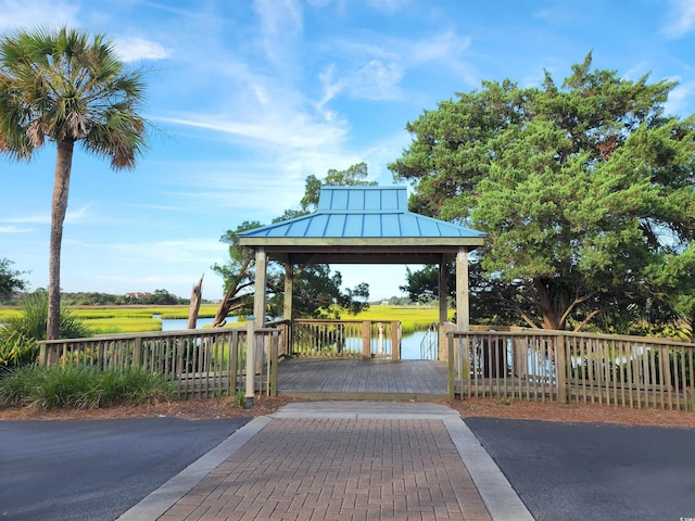 dock area with a gazebo and a deck with water view