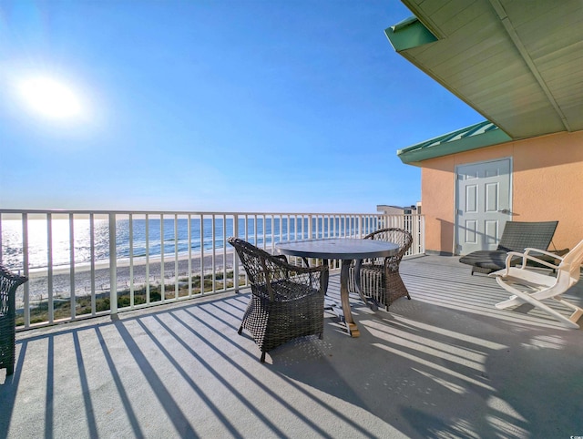 balcony featuring a beach view and a water view