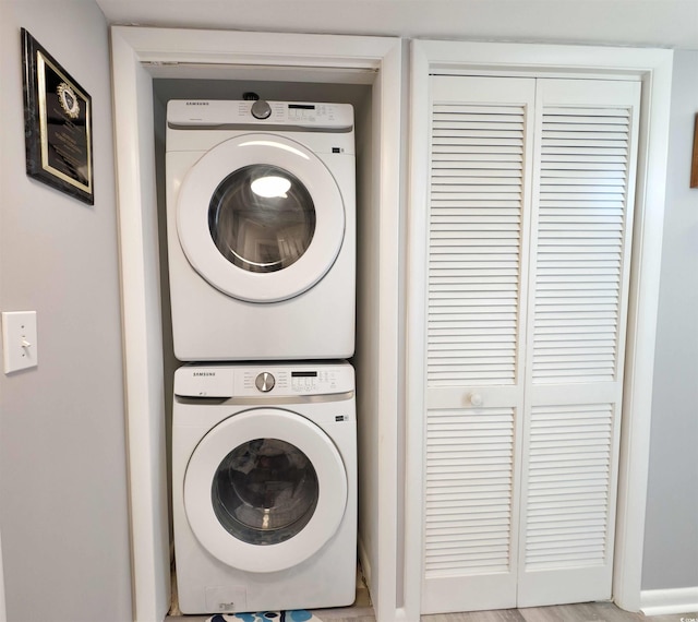 washroom featuring stacked washer and clothes dryer