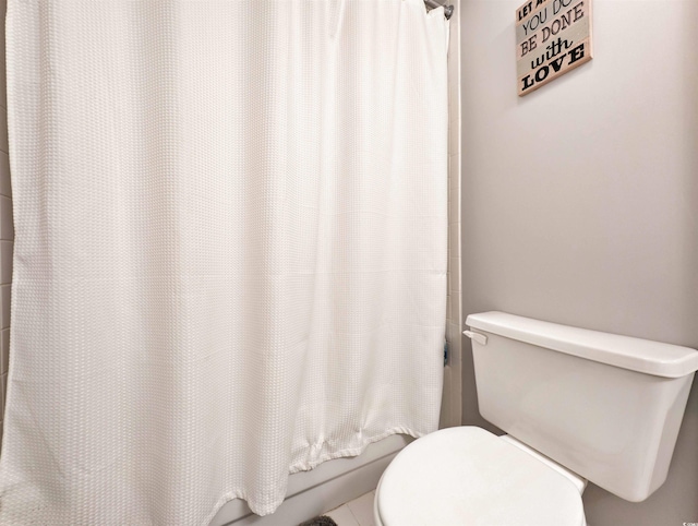 bathroom featuring a shower with curtain and toilet