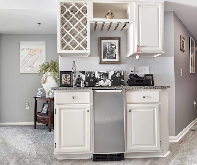 kitchen featuring white cabinets and light carpet