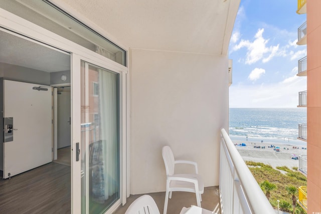 balcony featuring a water view and a beach view