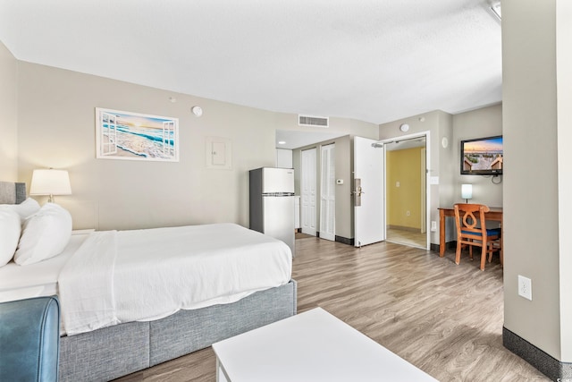 bedroom featuring wood-type flooring and a barn door