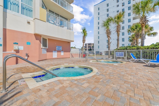 view of swimming pool with a patio area and a community hot tub