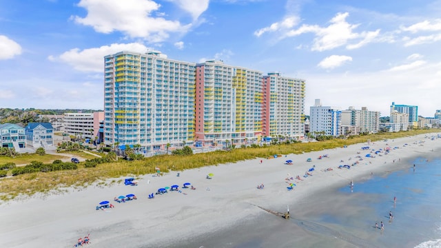 view of building exterior with a water view and a view of the beach