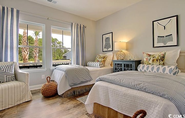 bedroom featuring visible vents, wood finished floors, and baseboards