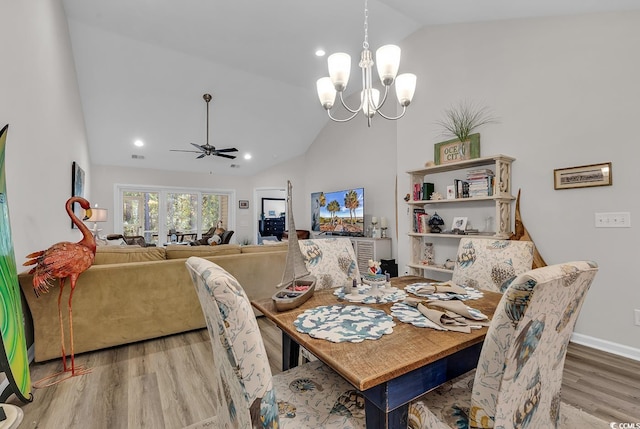 dining area with lofted ceiling, light hardwood / wood-style flooring, and ceiling fan with notable chandelier