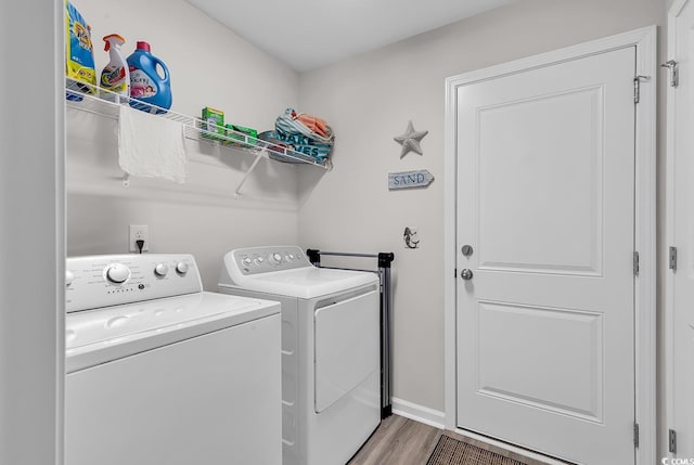 laundry room with hardwood / wood-style flooring and washer and clothes dryer