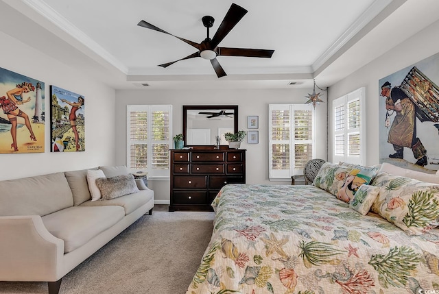 carpeted bedroom featuring multiple windows, a raised ceiling, and ceiling fan