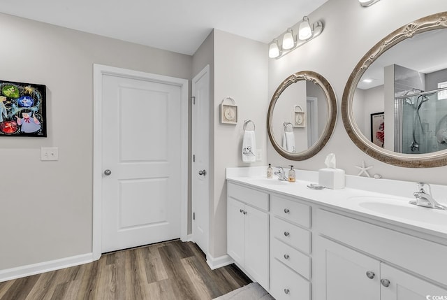 bathroom featuring vanity, a shower with shower door, and wood-type flooring