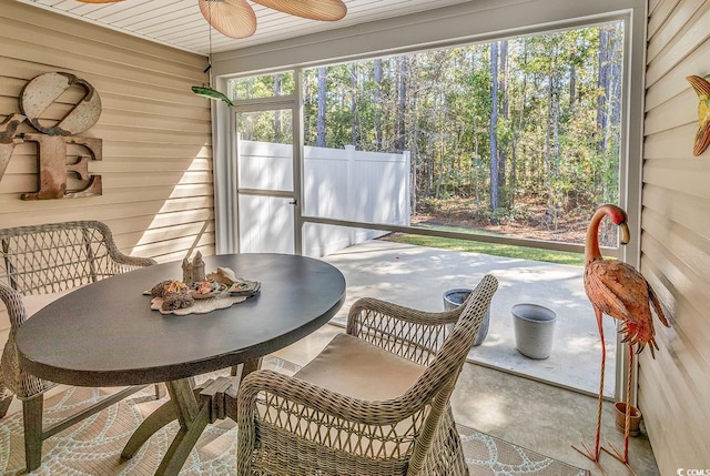 sunroom / solarium with ceiling fan, wood ceiling, and plenty of natural light