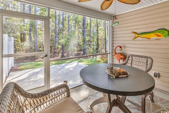 sunroom with ceiling fan, wooden ceiling, and a wealth of natural light