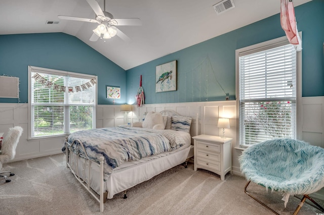 bedroom featuring light carpet, vaulted ceiling, multiple windows, and ceiling fan