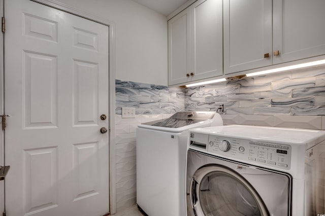 laundry room featuring independent washer and dryer and cabinets