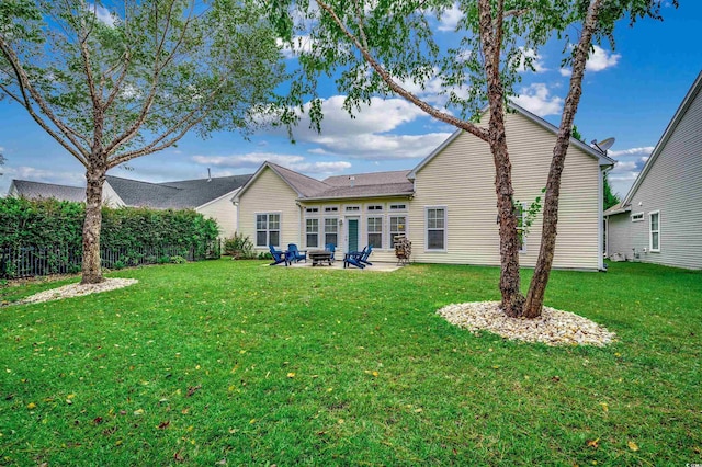 rear view of property featuring a lawn and a patio area