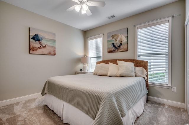 carpeted bedroom with multiple windows and ceiling fan