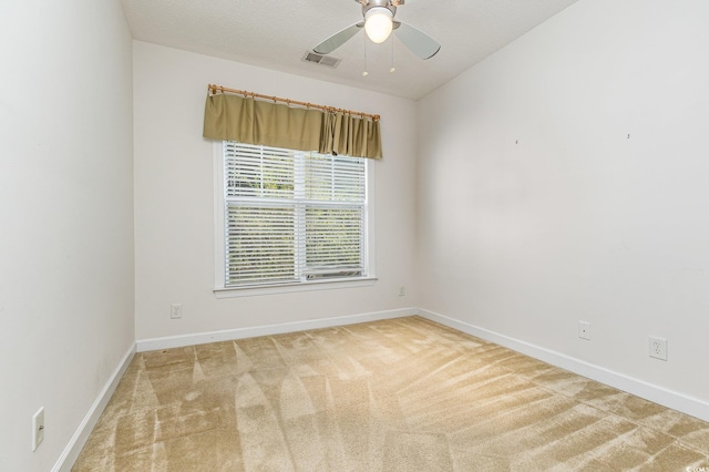 empty room with ceiling fan, carpet floors, and a textured ceiling