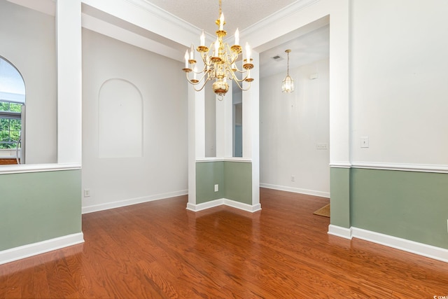 spare room featuring ornamental molding, hardwood / wood-style flooring, and a textured ceiling