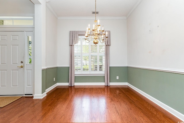 foyer entrance with a chandelier, crown molding, and hardwood / wood-style flooring