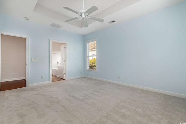 unfurnished bedroom featuring light carpet, connected bathroom, and ceiling fan