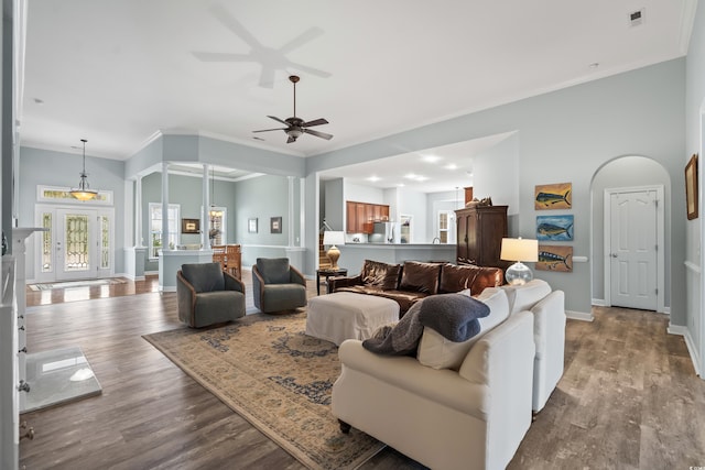 living room featuring ornamental molding, light hardwood / wood-style floors, and ceiling fan