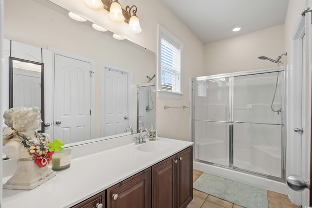 bathroom featuring a shower with door, vanity, and tile patterned flooring