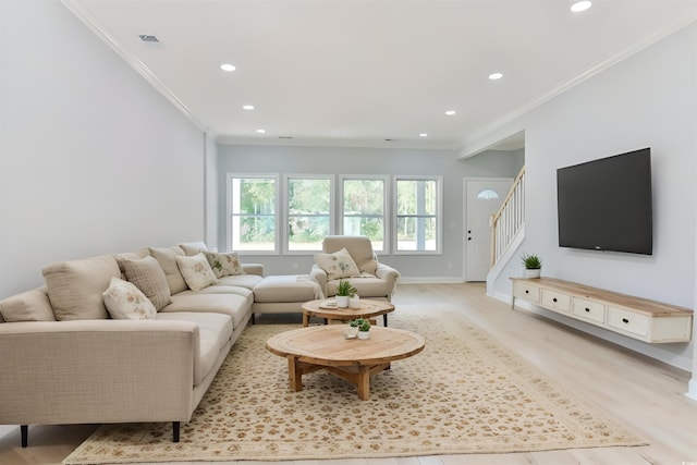 living room with ornamental molding and light hardwood / wood-style flooring