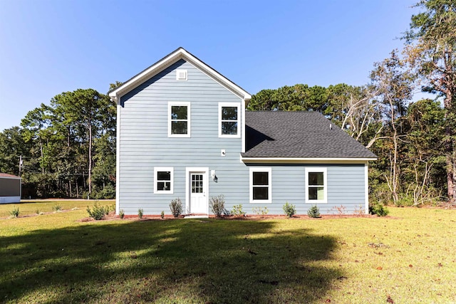 rear view of property featuring a lawn