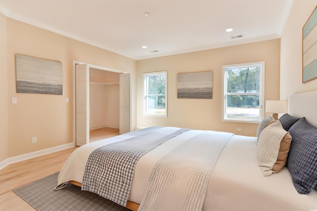 bedroom with ornamental molding, hardwood / wood-style floors, and multiple windows