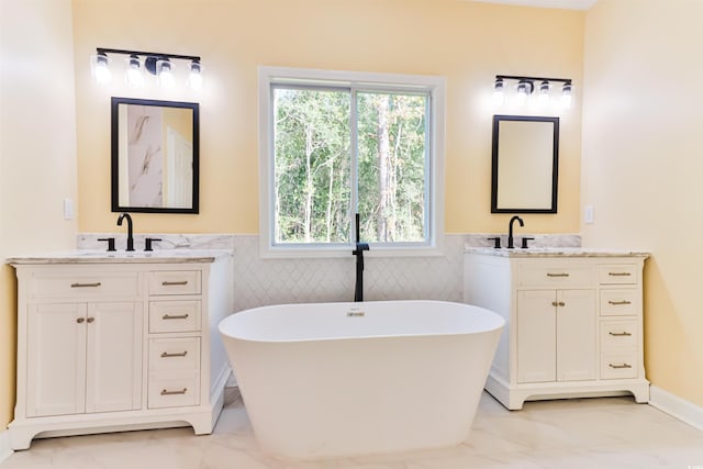 bathroom featuring vanity, a tub to relax in, and tile walls