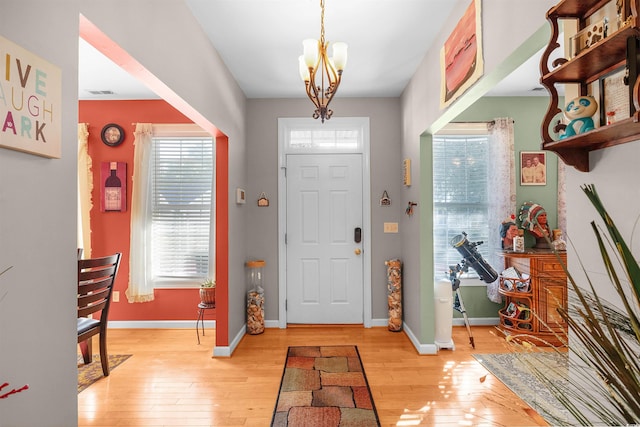 foyer entrance featuring light hardwood / wood-style floors and a chandelier