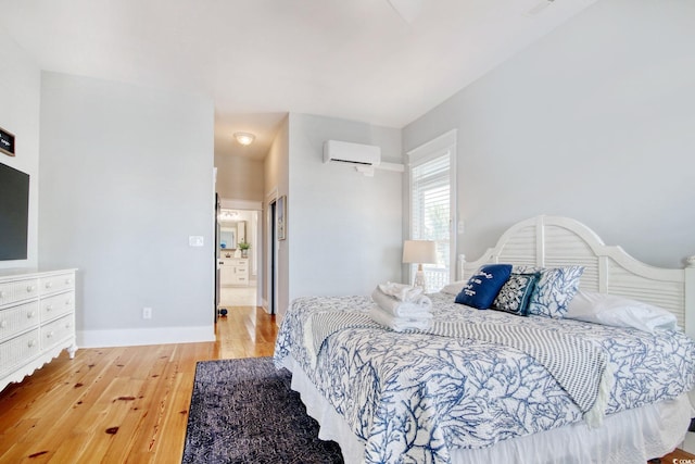 bedroom with a wall unit AC and hardwood / wood-style floors