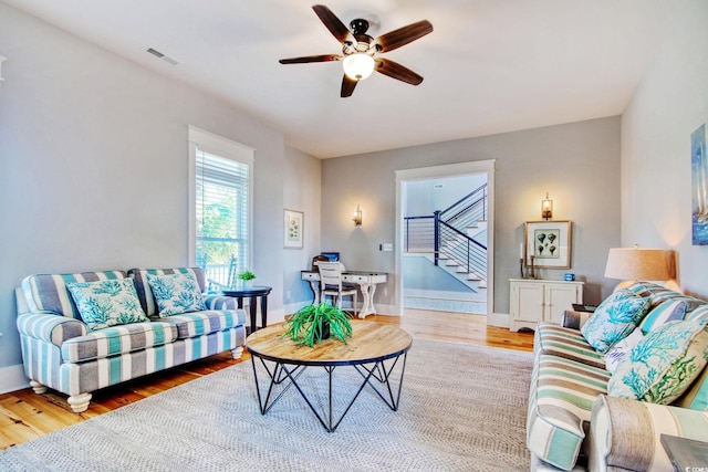 living room with light wood-type flooring and ceiling fan