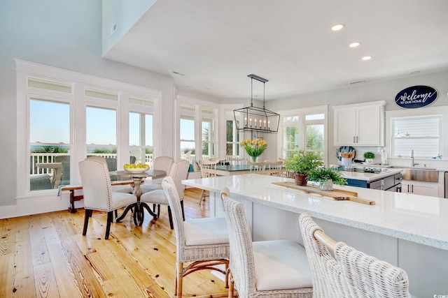 kitchen with light hardwood / wood-style floors, a wealth of natural light, and white cabinets