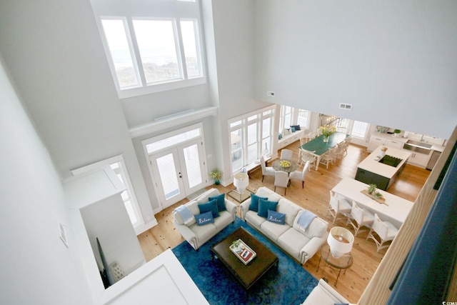 living room featuring french doors, hardwood / wood-style flooring, and a high ceiling